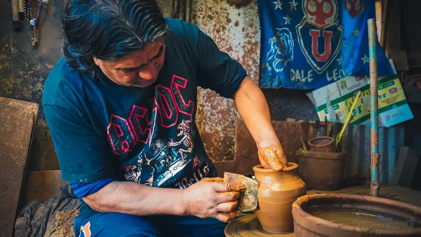 Local artisan shaping clay pottery as part of South American cultural heritage